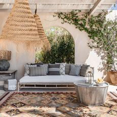 A sunsoaked garden nap area for outdoor sleeping, featuring a Nomad Xanthos Rug by Weaver Green