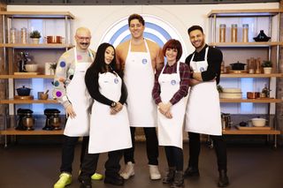 A group shot of the five contestants in the fourth heat of Celebrity MasterChef 2024 (L-R): Dominic Skinner, Mutya Buena, OJ Borg, Diane Carson, Vito Coppola, all in their MasterChef aprons.