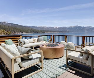 upper deck with fire pit and white lounge chairs overlooking mountains and lake