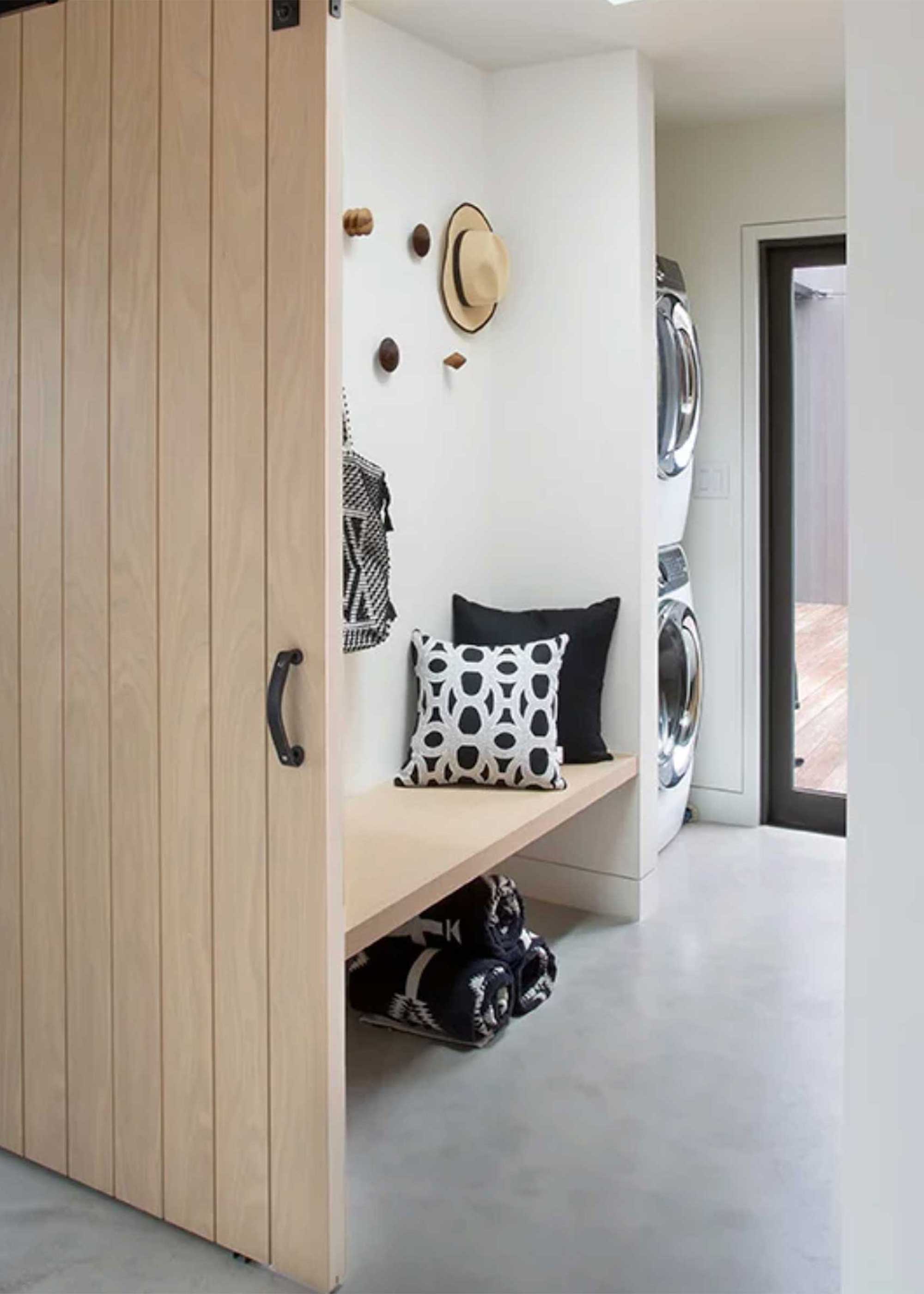 modern laundry room with poured concrete flooring and sliding barn door