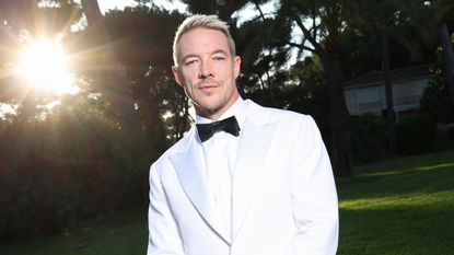 diplo outside wearing a white suit