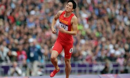 China's Xiang Liu limps down the track to the finish line after crashing into his first obstacle and losing his chance at the gold.