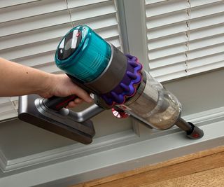 Testing the handheld mode of the Dyson Gen5detect on a baseboard