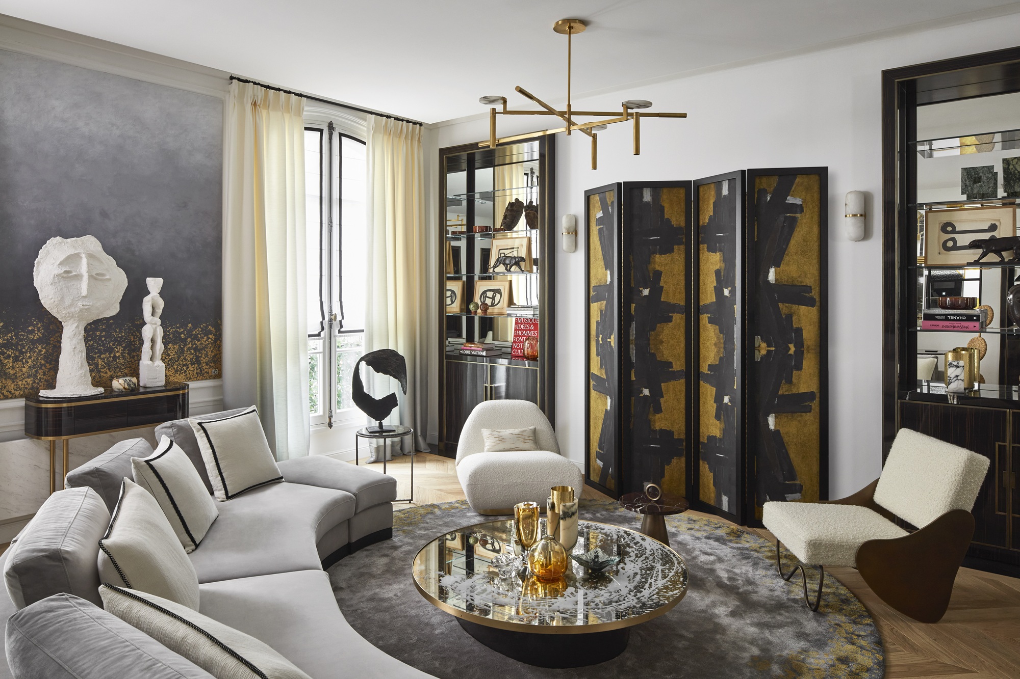 an art deco inspired living room with a curved sofa, mirror-backed cabinets and a folding screen covering a TV