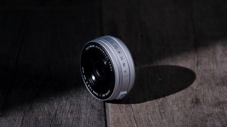The Fujifilm XF 23mm f/2.8 R WR on a gray wood-like surface