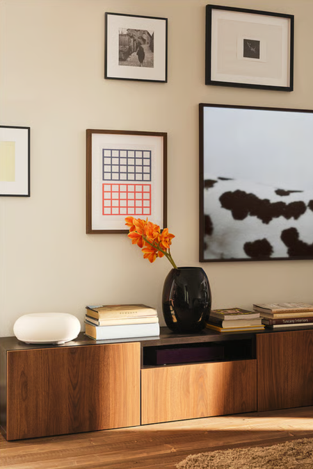 IKEA VARMBLIXT Smart Lamp styled atop of a wooden credenza alongside stacks of books and a sculptural vase