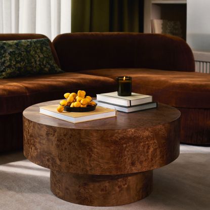 The John Lewis Burl Round Coffee Table in a retro-inspired modern living room with a curved brown velvet sofa
