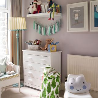 Neutral baby nursery in beige with white drawers