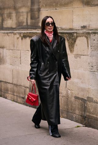 a street-style photo of a woman carrying a Hermés bag in a story about how to buy an hermés bag