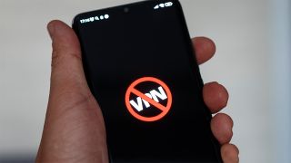 Person holding smartphone with VPN lettering crossed out