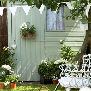garden shed with white flower pot and bunting