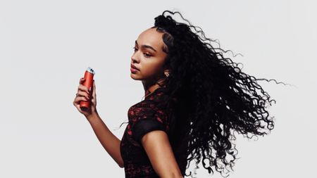 Woman holding red Dyson HushJet Mini Cool Fan
