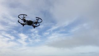 Ryze Tello drone in flight, against a blue sky