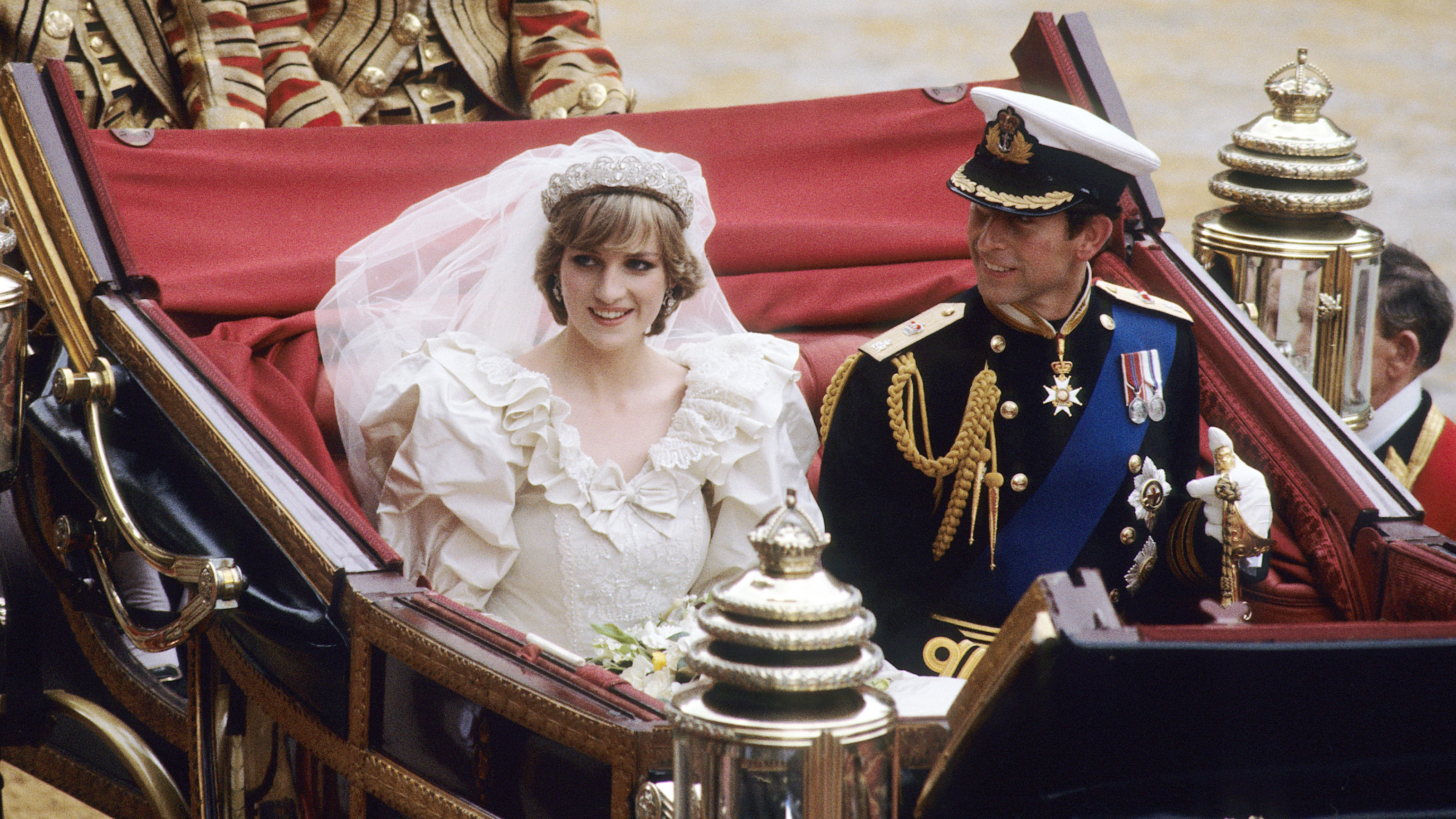 Diana, Princess of Wales, wearing a wedding dress designed by David and Elizabeth Emanuel and the Spencer family Tiara, rides with King Charles in an open carriage from St. Paul's Cathedral to Buckingham Palace, following their wedding on July 29, 1981