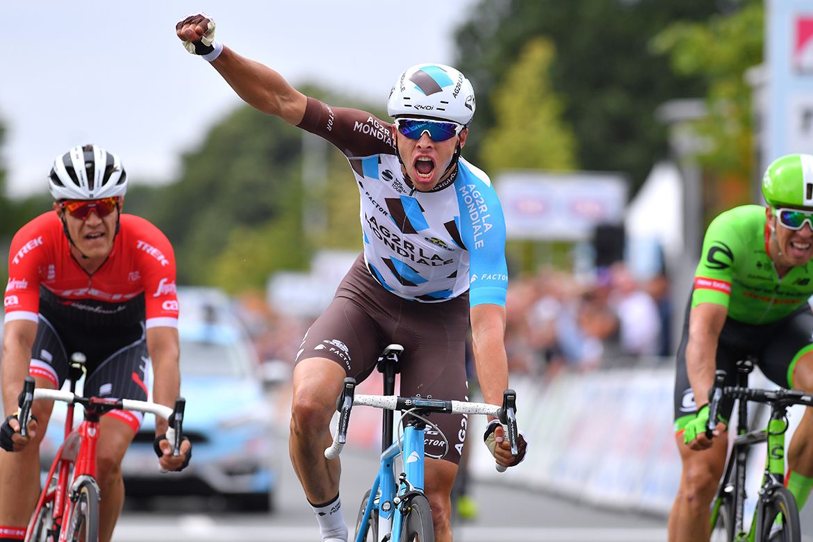 Oliver Naesen raises his arm in celebration