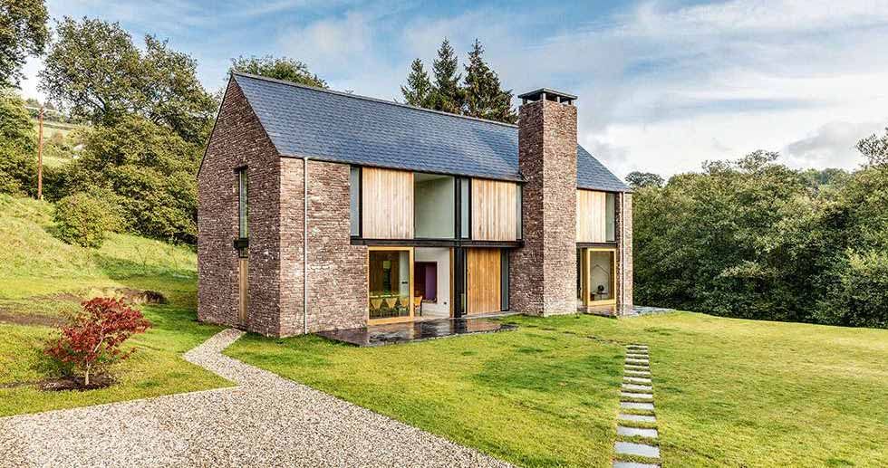 large stone self build barn house with garden pathway