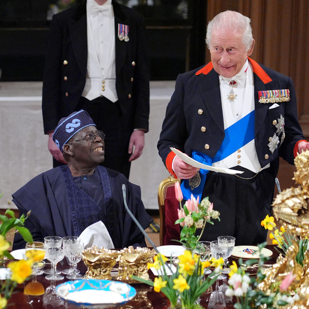 King Charles reading from a paper at a banquet table