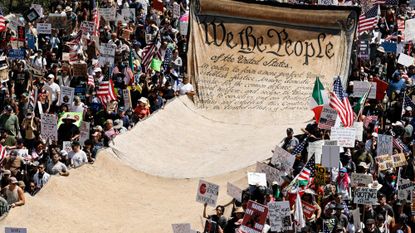 People carry a banner of the Constitution during an anti-Trump protest in Los Angeles