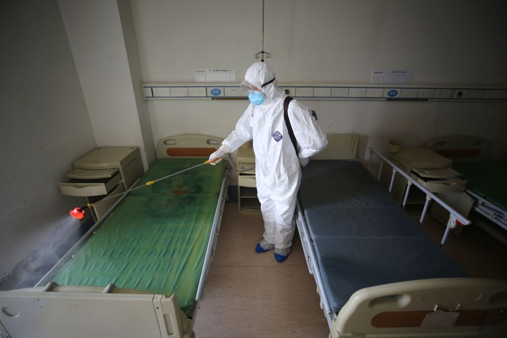 A health care worker sanitizes a hospital bed in China.