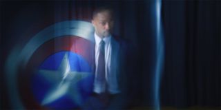 Anthony Mackie as Sam Wilson standing in the reflection of Captain America's shield in The Falcon And The Winter Soldier