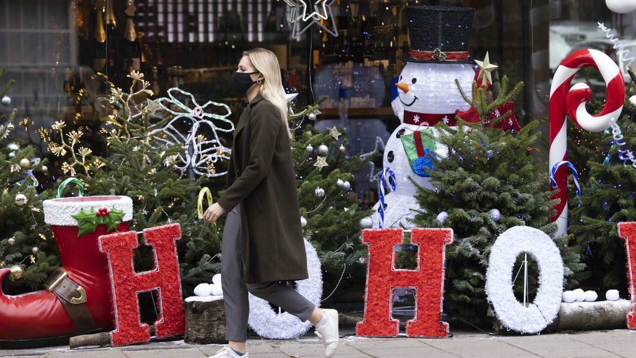 A woman walks past Christmas decorations in the West End, London