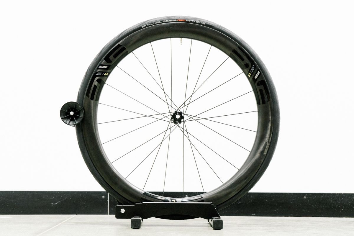 An aero road wheel stands against a white wall