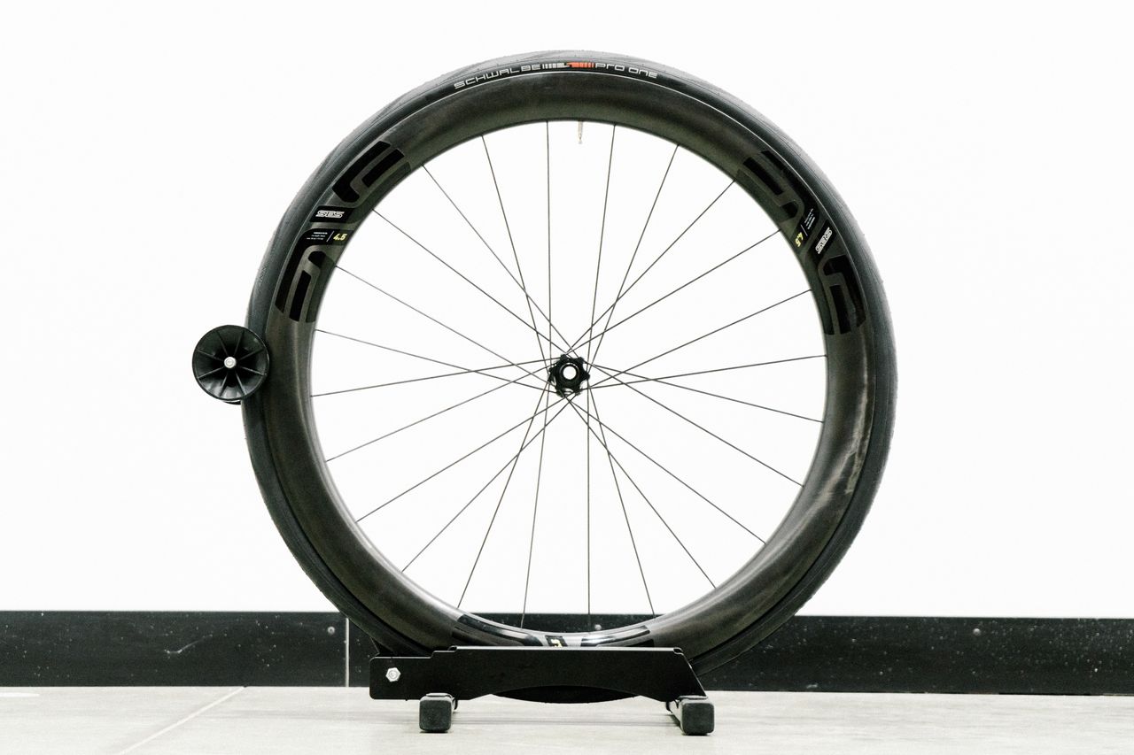 An aero road wheel stands against a white wall