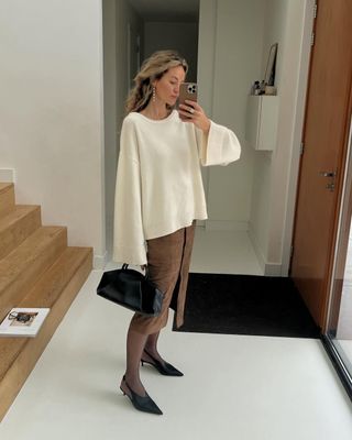 @anoukyve wearing a suede skirt and cream jumper