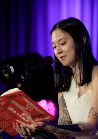 michelle zauner reads her book crying in h mart at a book event on stage