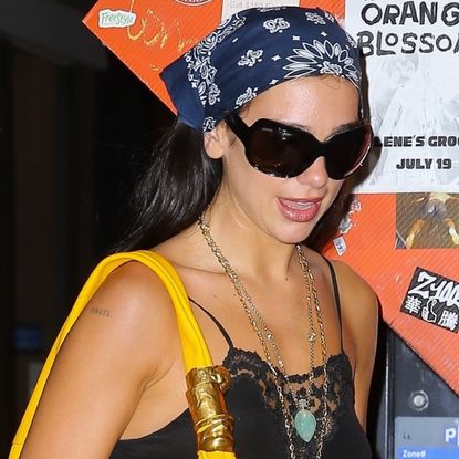 Dua Lipa styled the black and yellow color combination in a lacy LBD and an oversize Schiaparelli bag