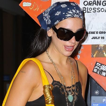 Dua Lipa styled the black and yellow color combination in a lacy LBD and an oversize Schiaparelli bag