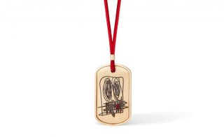 A 9 kt gold dog tag pendant engraved with a ruby