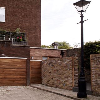 exterior with parking space and brick wall with street lamp