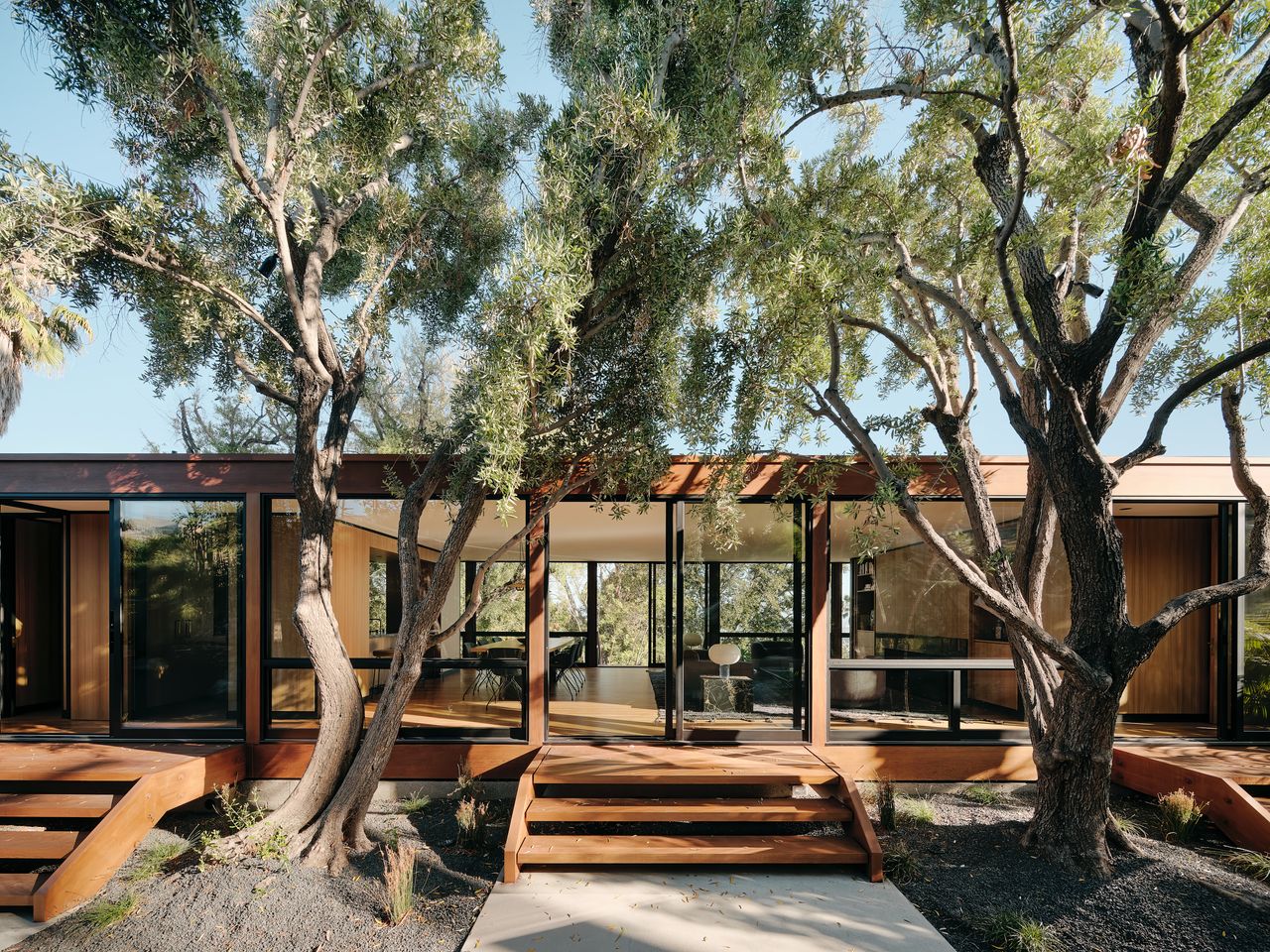 Exterior of a house with two large trees on either side of the house