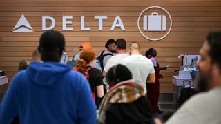 Delta Airlines passengers waiting at a customer service desk during the CrowdStrike outage in July 2024.