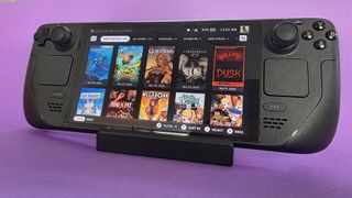 A Steam Deck OLED handheld gaming console on a solid purple background