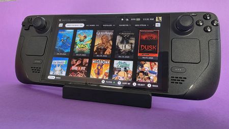 A Steam Deck OLED handheld gaming console on a solid purple background
