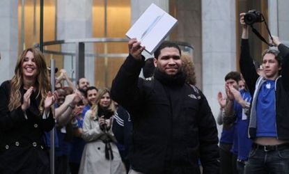 The first customer to purchase the new iPad exits triumphant at the New York City Apple: While CEO Tim Cook says iPad sales broke records, critics say the excitement was subdued. 
