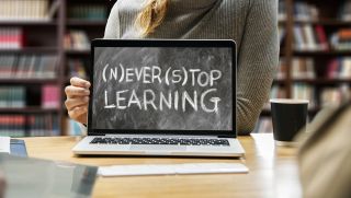 Laptop computer displays "Never Stop Learning"