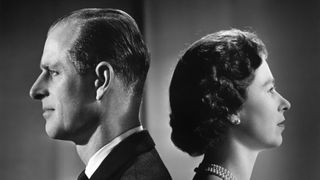Prince Philip and Queen Elizabeth standing back to back in a black and white portrait