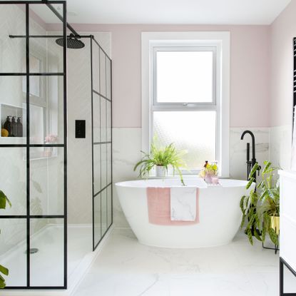 Pink and white marble bathroom with a white freestanding bathtub
