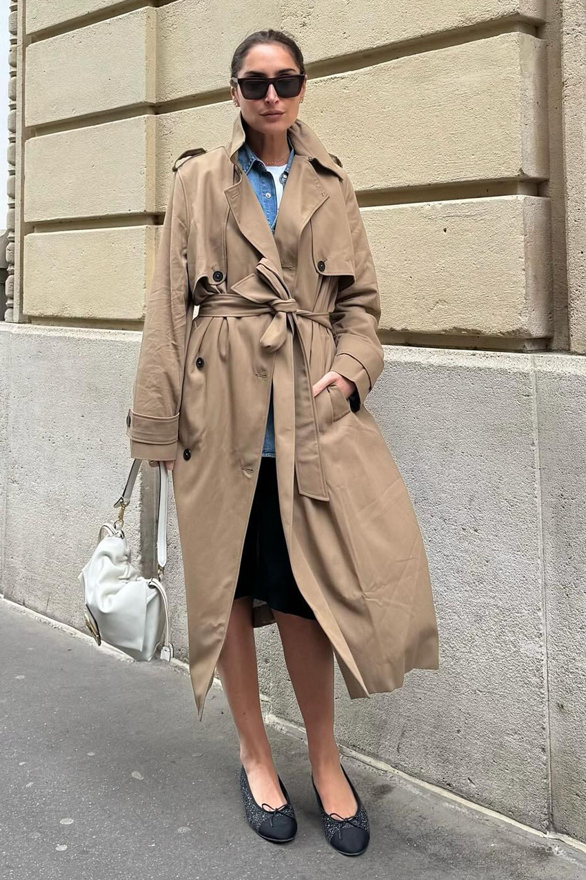 A woman wearing trench coat and a knee-length skirt