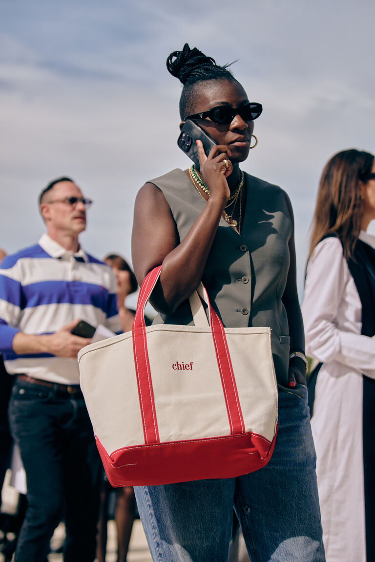 Nikki Ogunnaike carrying an L.L. Bean boat and tote bag at paris fashion week