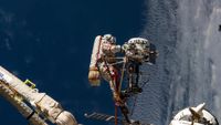 Cosmonaut Sergey Ryzhikov is seen at the end of the European robotic arm as he works on a high‑resolution camera during a 6-hour spacewalk outside the International Space Station on Oct. 16, 2025.