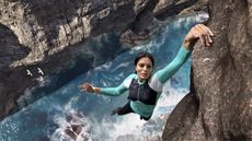 woman hanging from cliff