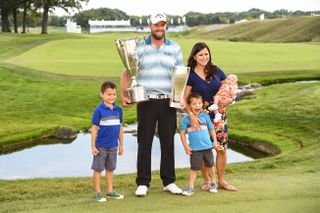 Leishman holds the trophy with his family