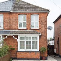 sloping roof house with exposed brick walls and white windows