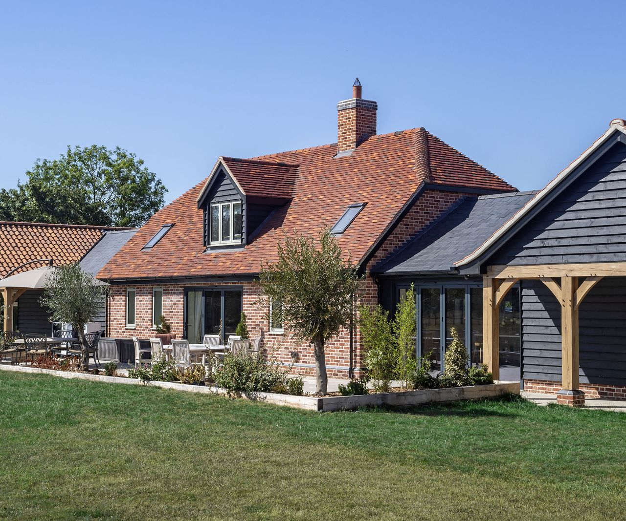 Beautiful pitched roof barn-style home clad in black timber and brick