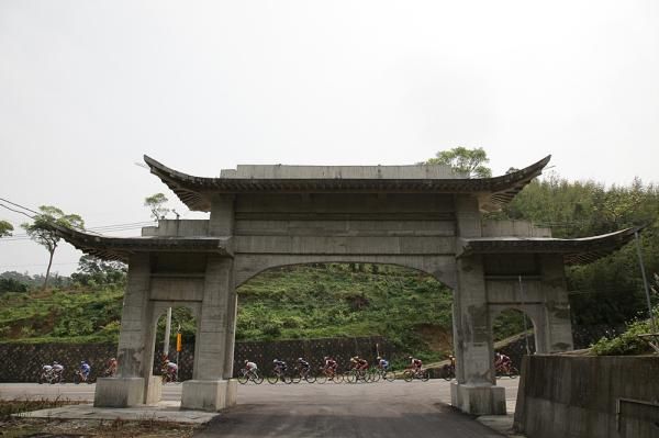 A temple gate towers over the peloton