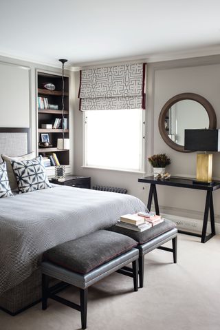 Grey bedroom with circular mirror